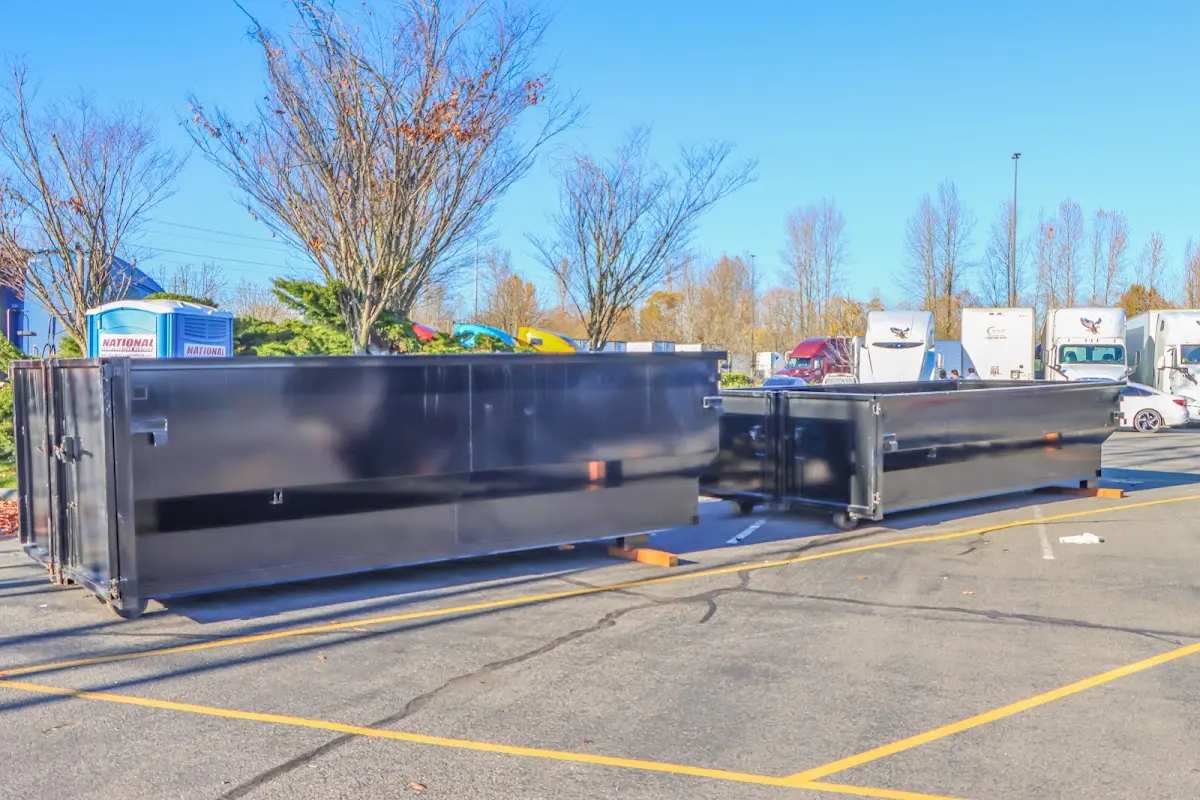 Professional dumpster rental service with roll-off container on residential driveway in Clive